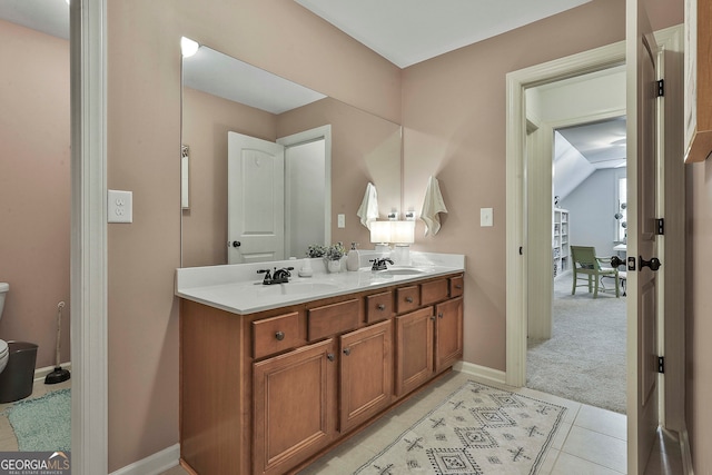 bathroom with toilet, vanity, and tile patterned floors