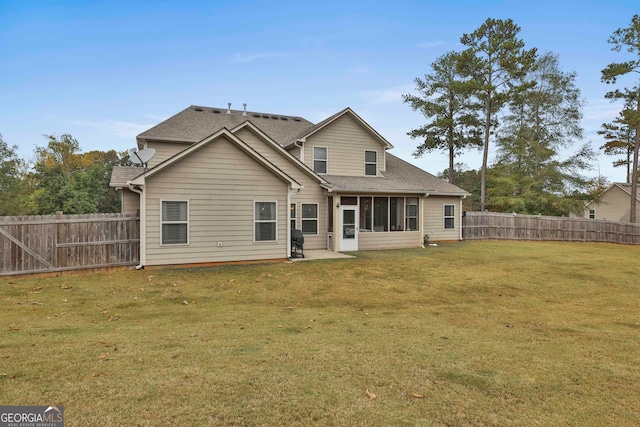 rear view of house featuring a lawn and a sunroom