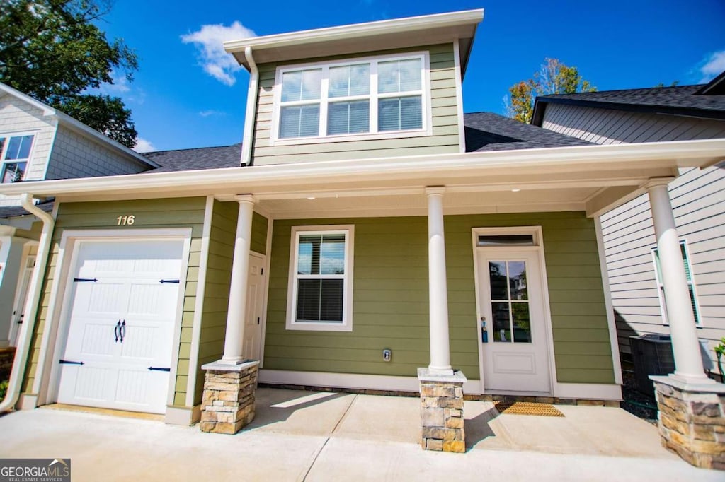 view of front facade featuring covered porch and a garage