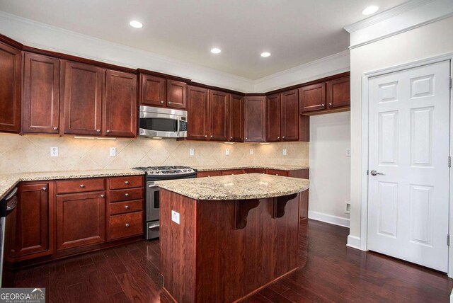 kitchen with light stone counters, a center island, dark wood-type flooring, and appliances with stainless steel finishes