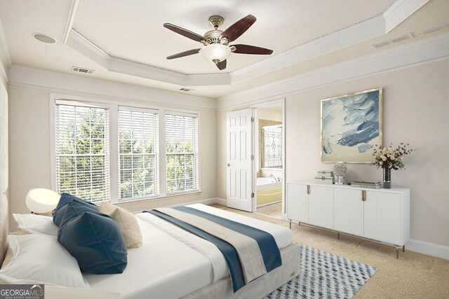 bedroom with ensuite bath, ornamental molding, light colored carpet, a raised ceiling, and ceiling fan