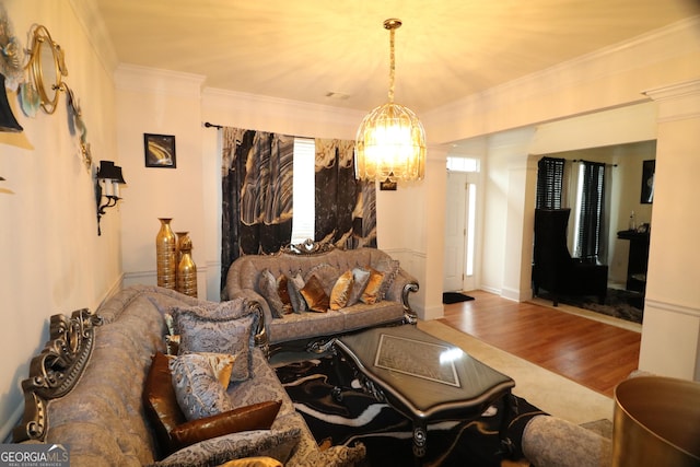 living room with hardwood / wood-style floors, a chandelier, and ornamental molding