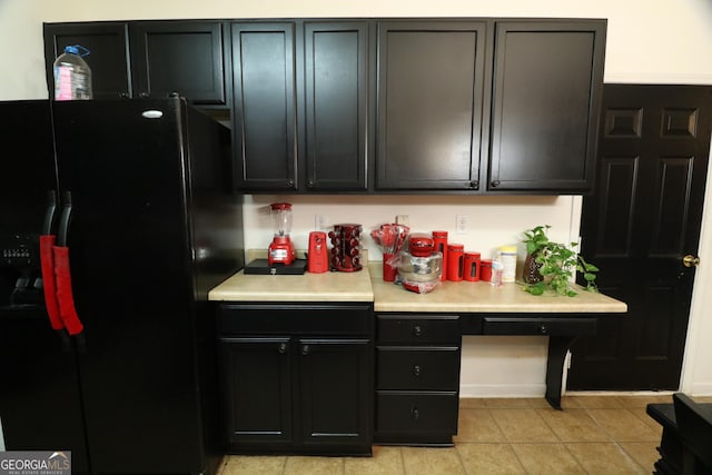 kitchen featuring light tile patterned floors and black refrigerator with ice dispenser