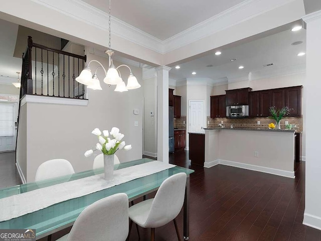 dining room with ornamental molding, dark hardwood / wood-style flooring, and decorative columns