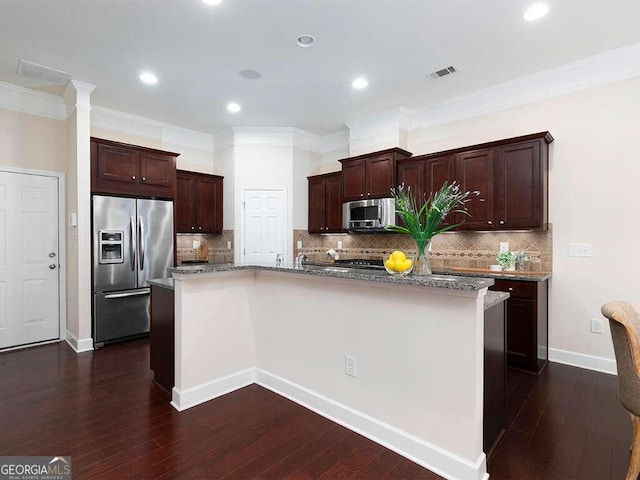 kitchen featuring an island with sink, dark hardwood / wood-style floors, and stainless steel appliances