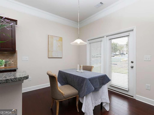 dining area with dark hardwood / wood-style floors and crown molding