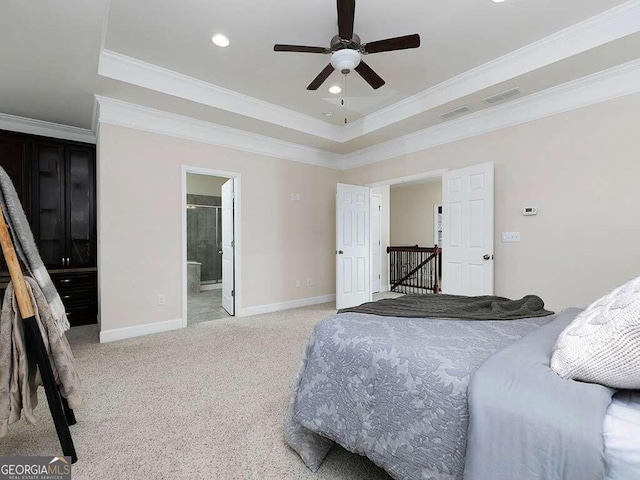 bedroom featuring ensuite bathroom, ceiling fan, a raised ceiling, crown molding, and light colored carpet