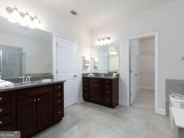 bathroom featuring vanity, tile patterned floors, and plus walk in shower