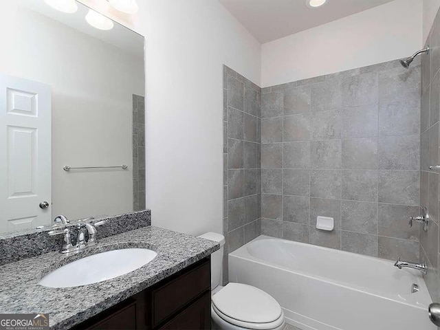 full bathroom with tiled shower / bath, toilet, and vanity