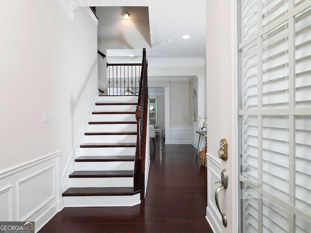 stairs featuring wood-type flooring and ornamental molding