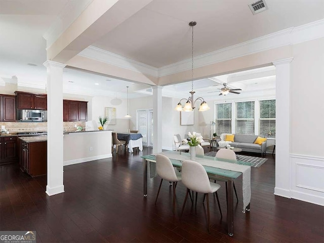 dining room featuring ceiling fan with notable chandelier, beam ceiling, crown molding, decorative columns, and dark wood-type flooring