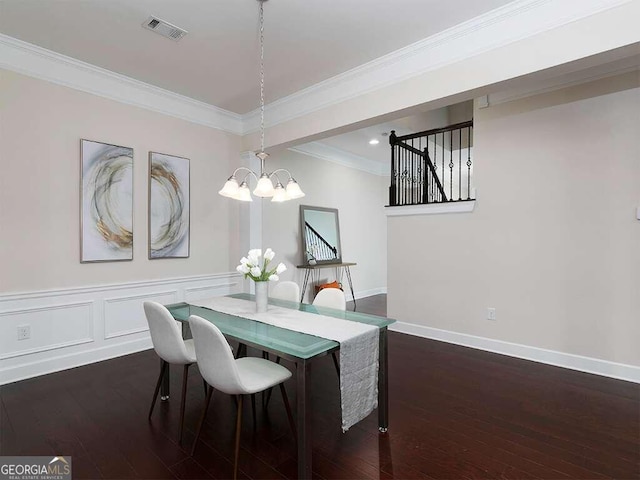 dining area featuring dark wood-type flooring, a chandelier, and ornamental molding