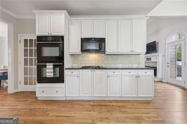 kitchen with black appliances, dark stone countertops, and white cabinetry