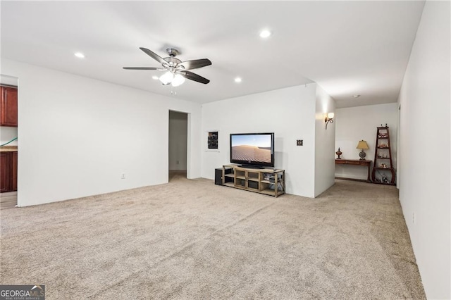 unfurnished living room featuring ceiling fan and light colored carpet