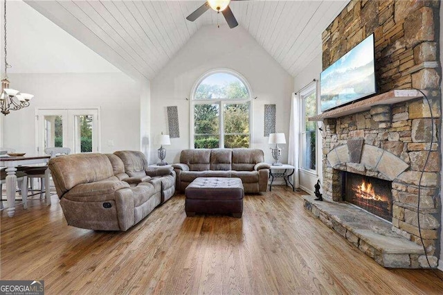 living room with ceiling fan, high vaulted ceiling, hardwood / wood-style floors, a fireplace, and wood ceiling