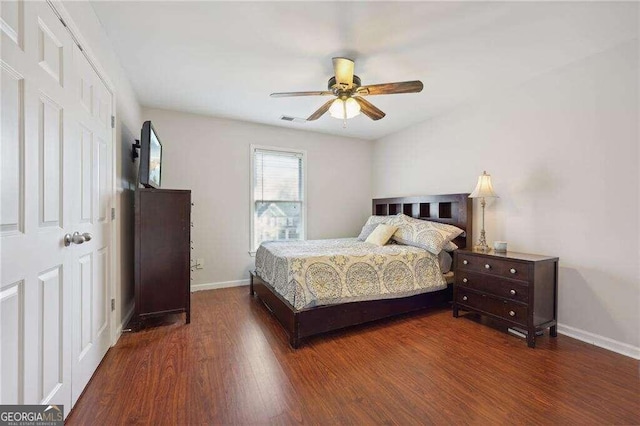 bedroom with dark hardwood / wood-style flooring, a closet, and ceiling fan