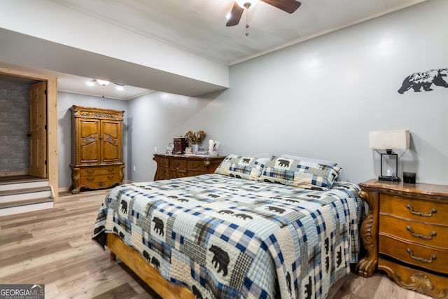 bedroom featuring light hardwood / wood-style floors, ceiling fan, and crown molding