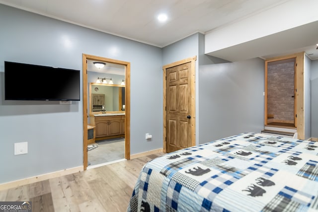 bedroom with ensuite bath, a closet, and light hardwood / wood-style flooring