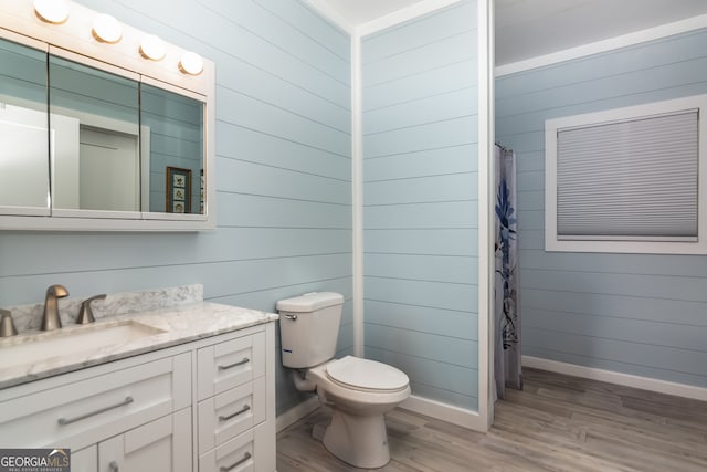 bathroom featuring wood walls, hardwood / wood-style flooring, vanity, and walk in shower