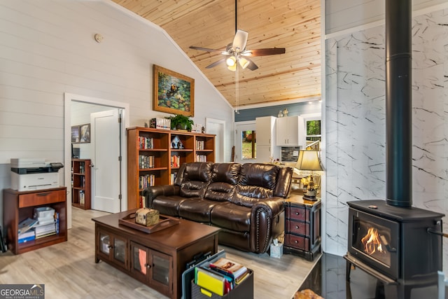 living room featuring wood ceiling, a wood stove, high vaulted ceiling, ceiling fan, and light hardwood / wood-style flooring