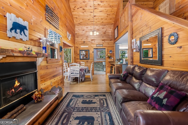 living room featuring high vaulted ceiling, wooden walls, wood-type flooring, and wooden ceiling