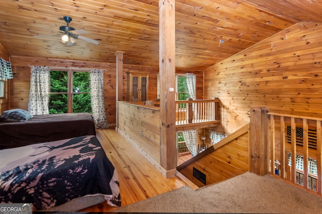 bedroom featuring wood-type flooring, vaulted ceiling, wood ceiling, wooden walls, and ceiling fan