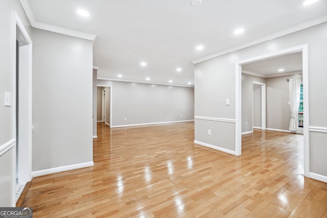 spare room featuring light hardwood / wood-style flooring and crown molding