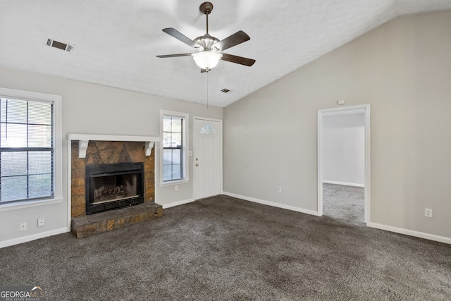 unfurnished living room featuring a fireplace, ceiling fan, a healthy amount of sunlight, and lofted ceiling