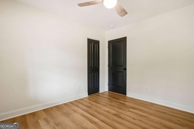 empty room with ceiling fan and light hardwood / wood-style flooring