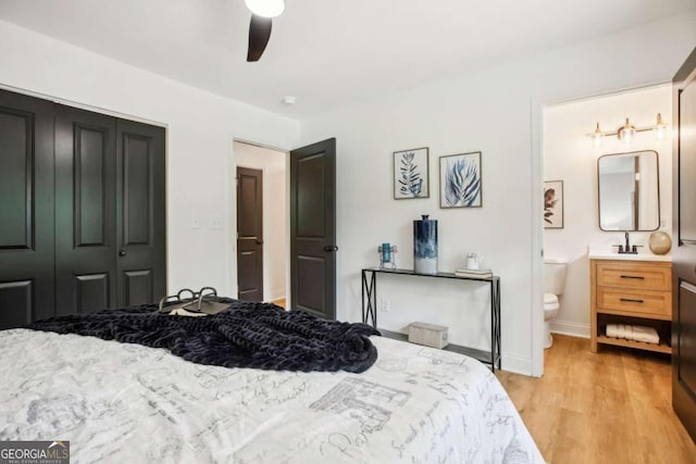 bedroom featuring light hardwood / wood-style floors, ceiling fan, a closet, and ensuite bathroom