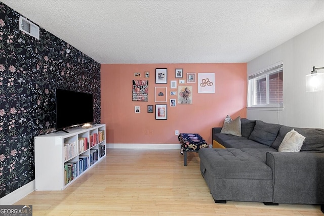 living room featuring light hardwood / wood-style floors and a textured ceiling