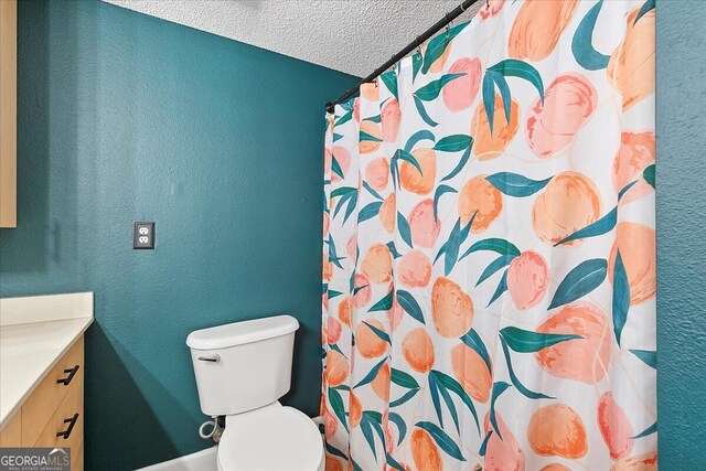 bathroom featuring vanity, a textured ceiling, and toilet