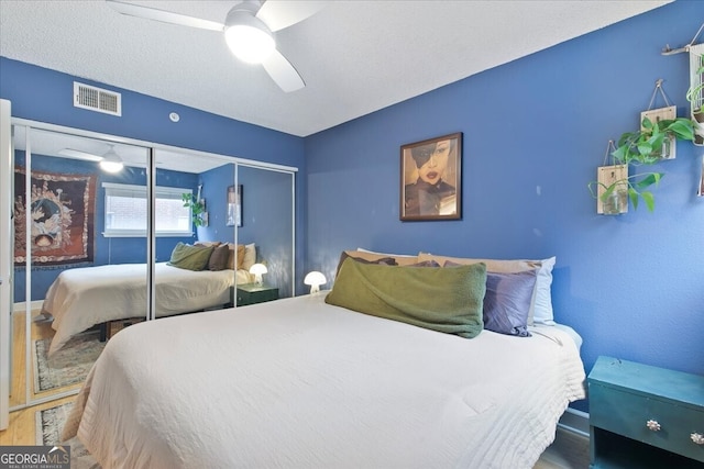 bedroom with hardwood / wood-style flooring, ceiling fan, and a closet