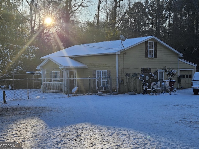 snow covered back of property with a porch