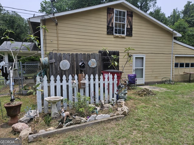 back of house with a garage and a yard