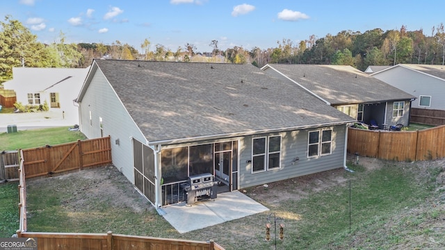 rear view of house featuring a patio, a lawn, and a sunroom