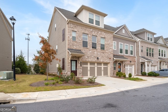 townhome / multi-family property with a front yard and a garage