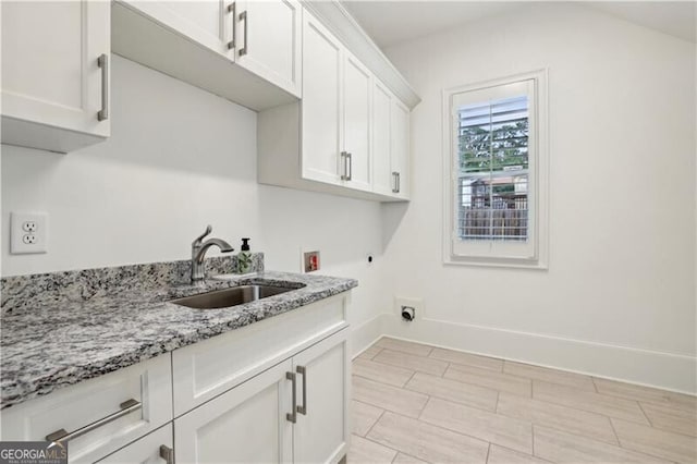 clothes washing area with cabinets, hookup for a washing machine, sink, and electric dryer hookup