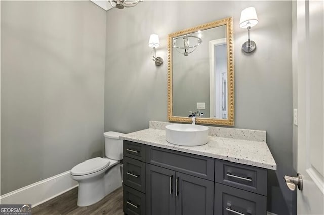 bathroom with vanity, hardwood / wood-style flooring, and toilet