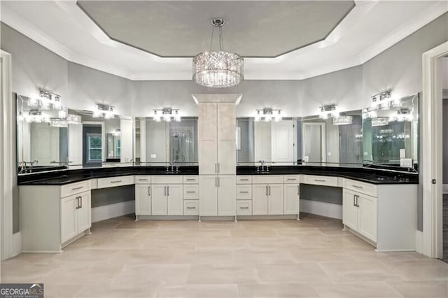 bathroom featuring vanity, a chandelier, and a raised ceiling