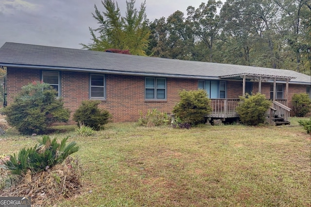 ranch-style home with a front yard and a deck