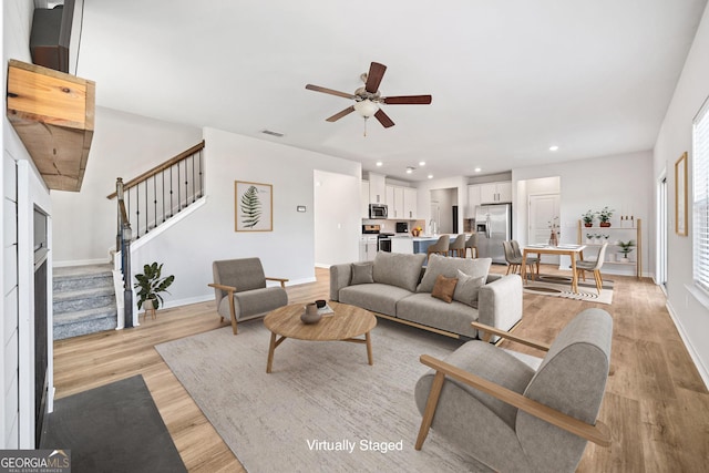 living room featuring ceiling fan and light hardwood / wood-style flooring