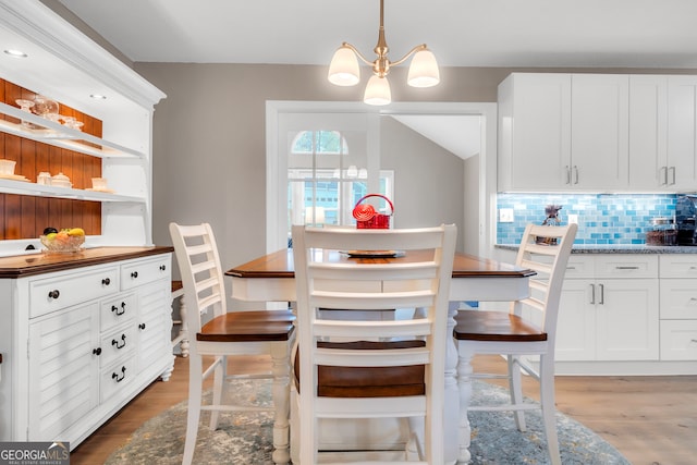 dining space with wood-type flooring and a notable chandelier