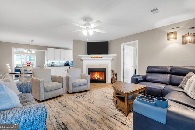 living room featuring ceiling fan and light hardwood / wood-style flooring