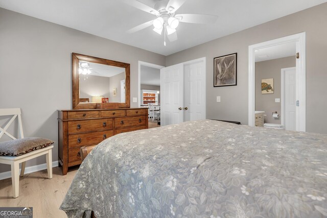 bedroom with connected bathroom, light hardwood / wood-style flooring, and ceiling fan