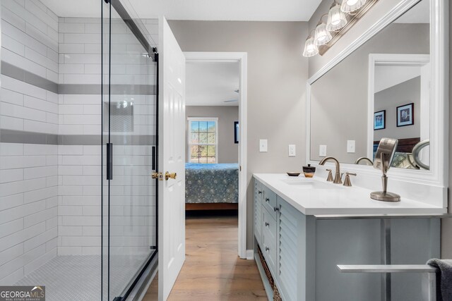 bathroom with hardwood / wood-style flooring, vanity, and walk in shower