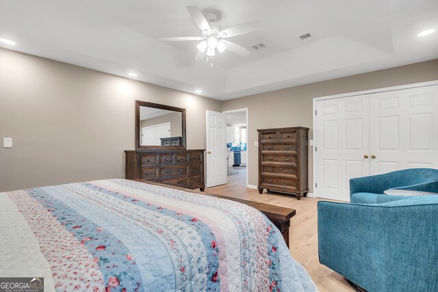 bedroom with ceiling fan, a closet, and light hardwood / wood-style floors