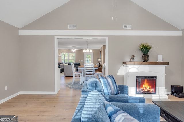 living room with hardwood / wood-style flooring, high vaulted ceiling, and ceiling fan