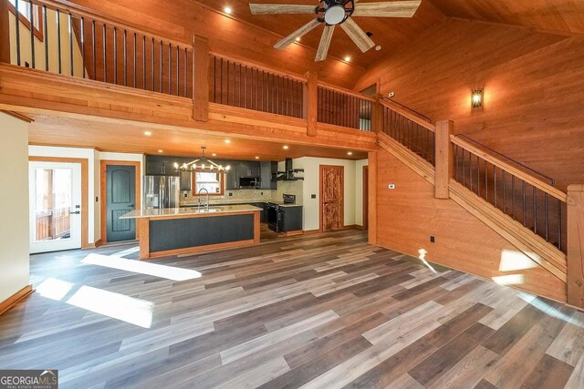 kitchen featuring stainless steel appliances, exhaust hood, sink, a center island with sink, and dark hardwood / wood-style floors