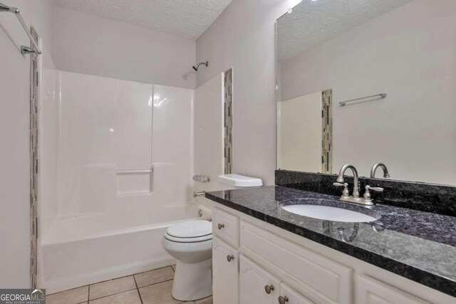 full bathroom with toilet, tile patterned flooring, a textured ceiling, vanity, and bathtub / shower combination